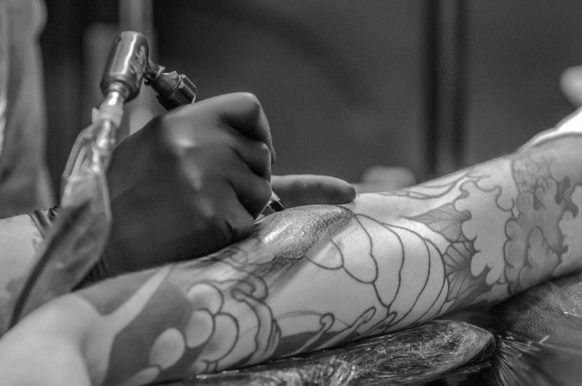 Tatuator robi tatuaż krzyż mężczyźnie